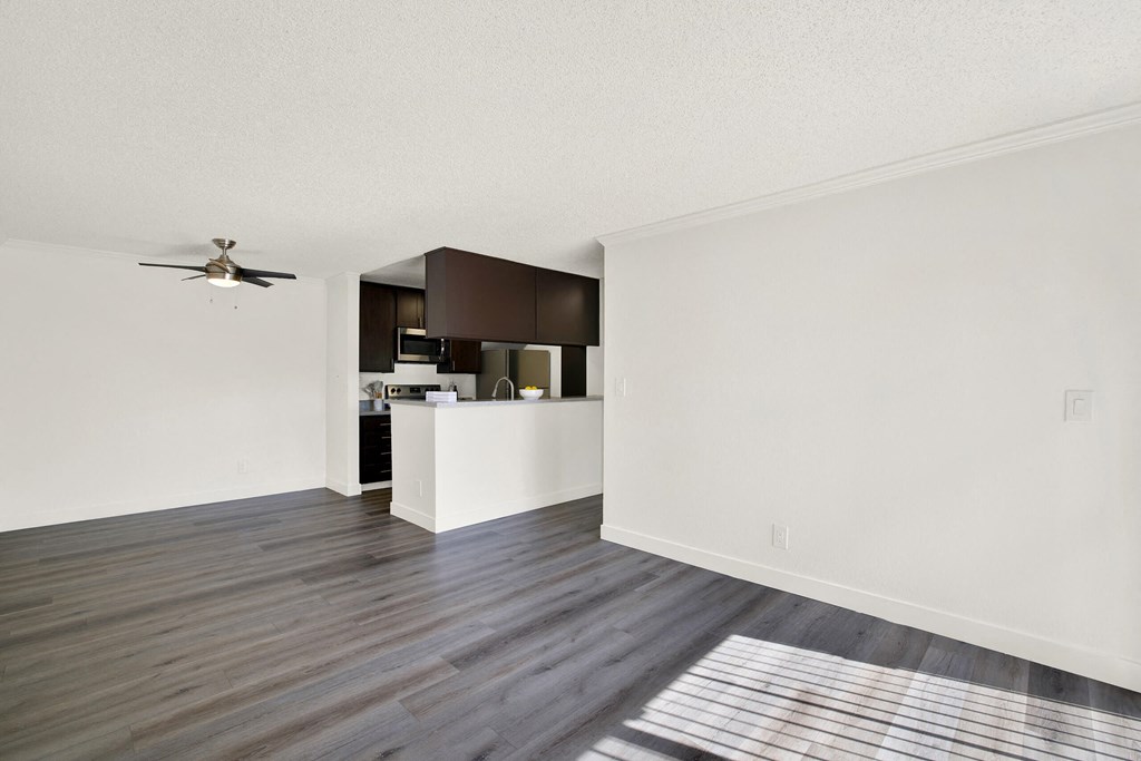 an empty living room and kitchen with a ceiling fan at Monterra Ridge Apartments, Canyon Country