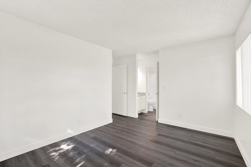 an empty living room with white walls and wood floors at Monterra Ridge Apartments, Canyon Country