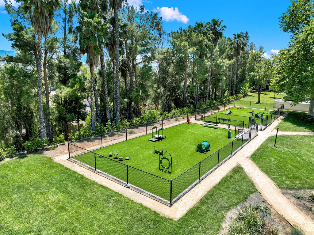 a tennis court in a park with trees at Monterra Ridge Apartments,California