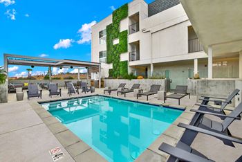 a swimming pool with lounge chairs and a building in the background at the perch, Los Angeles, CA