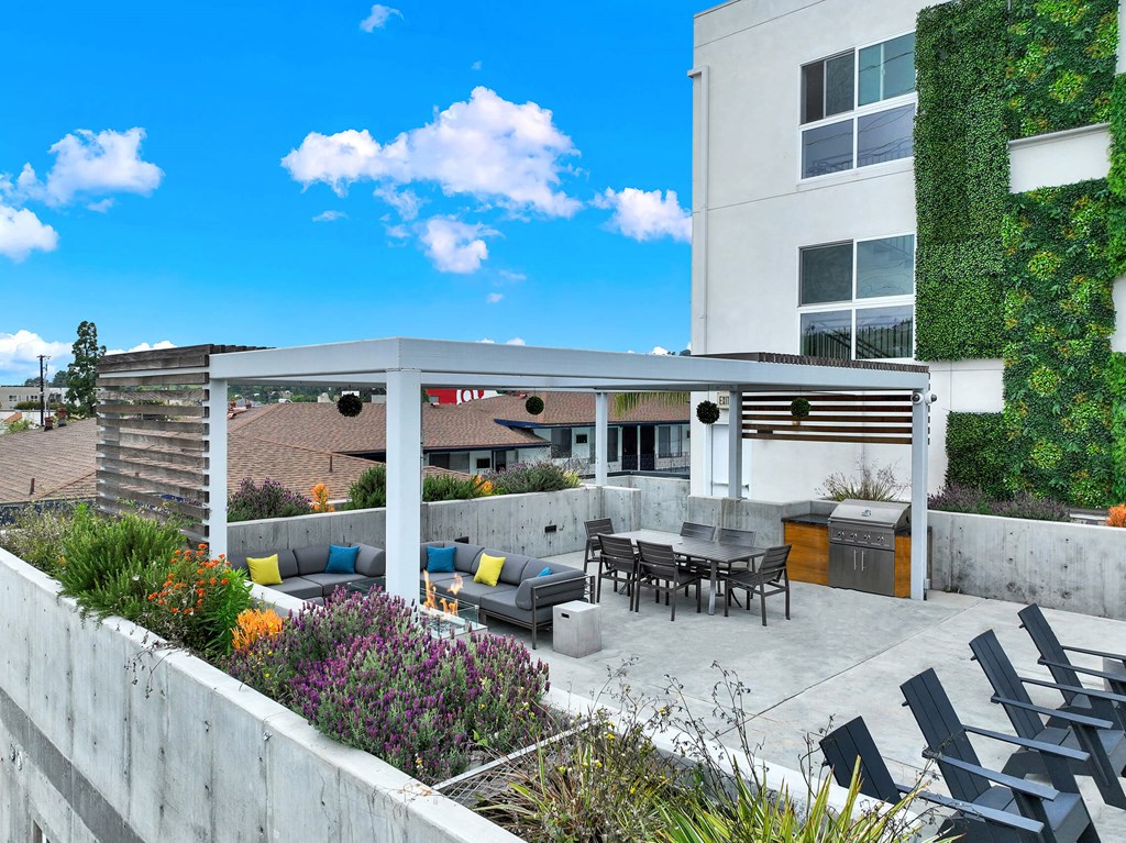 a rendering of a patio with tables and chairs in front of a building