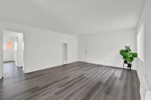 an empty living room with white walls and wood floors at Sunset Square Apartments, West Covina, California, 91790