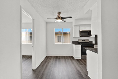 an empty kitchen with a ceiling fan and a window at Sunset Square Apartments, West Covina, California, 91790