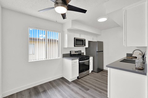 an open kitchen with a window and a ceiling fan at Sunset Square Apartments, West Covina, California, 91790