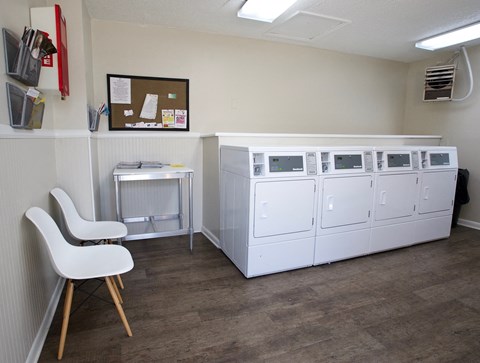 Laundry facilities at Countryside Villa with washer, dryers, folding table, and chairs
