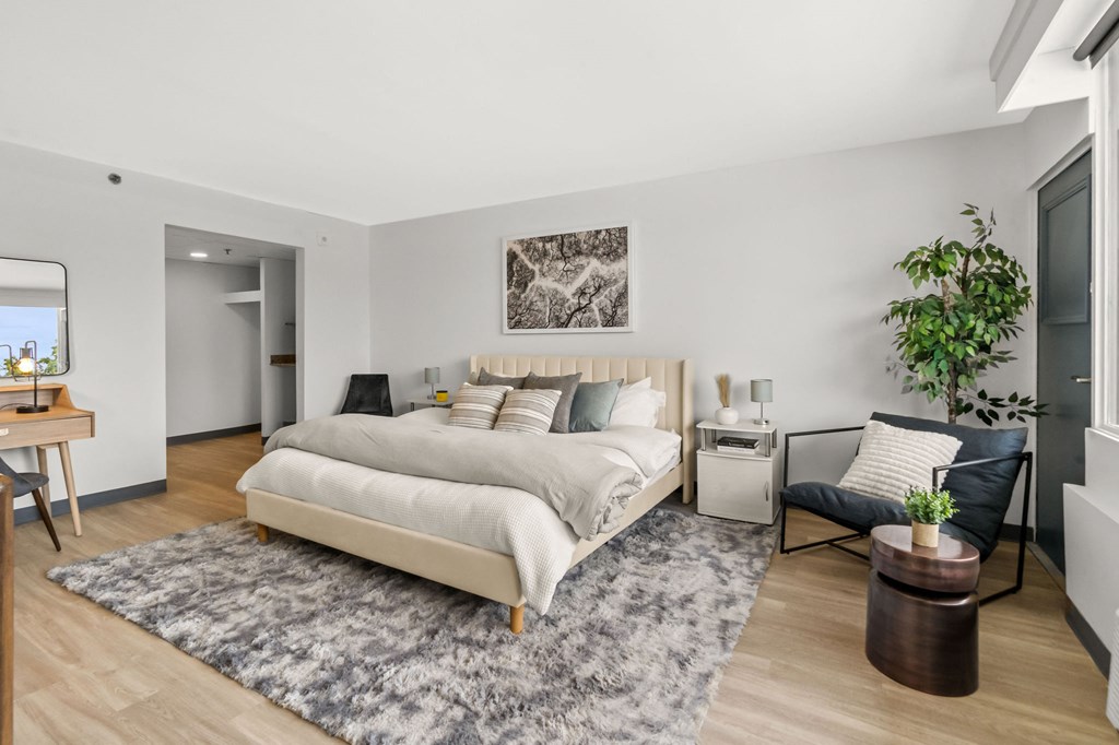 A bedroom with a large bed and a chair.