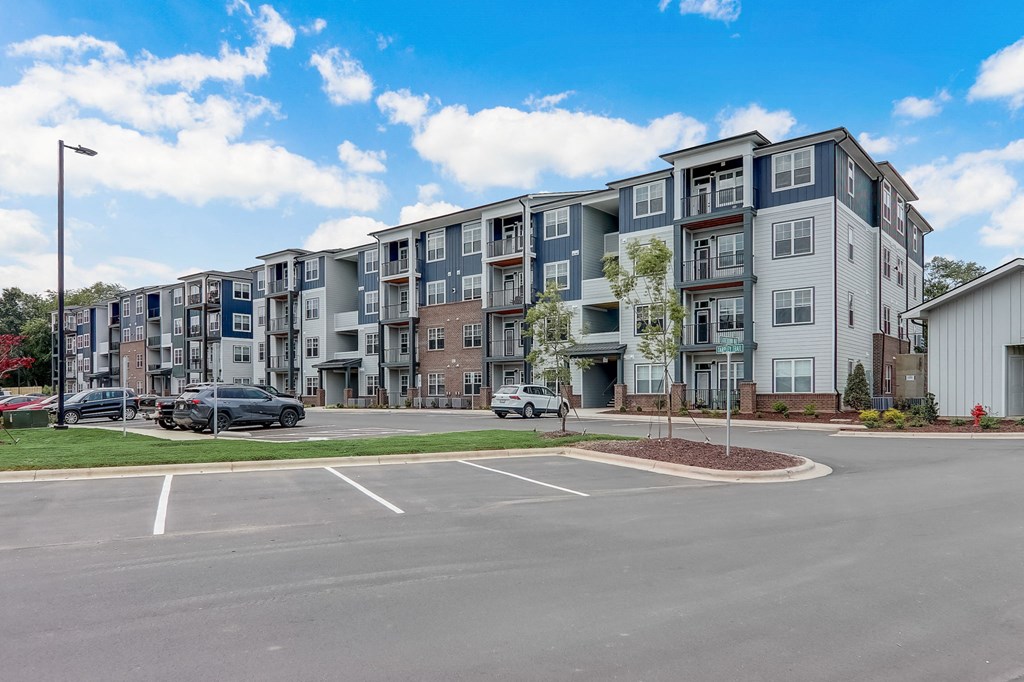 a large parking lot with an apartment building in the background