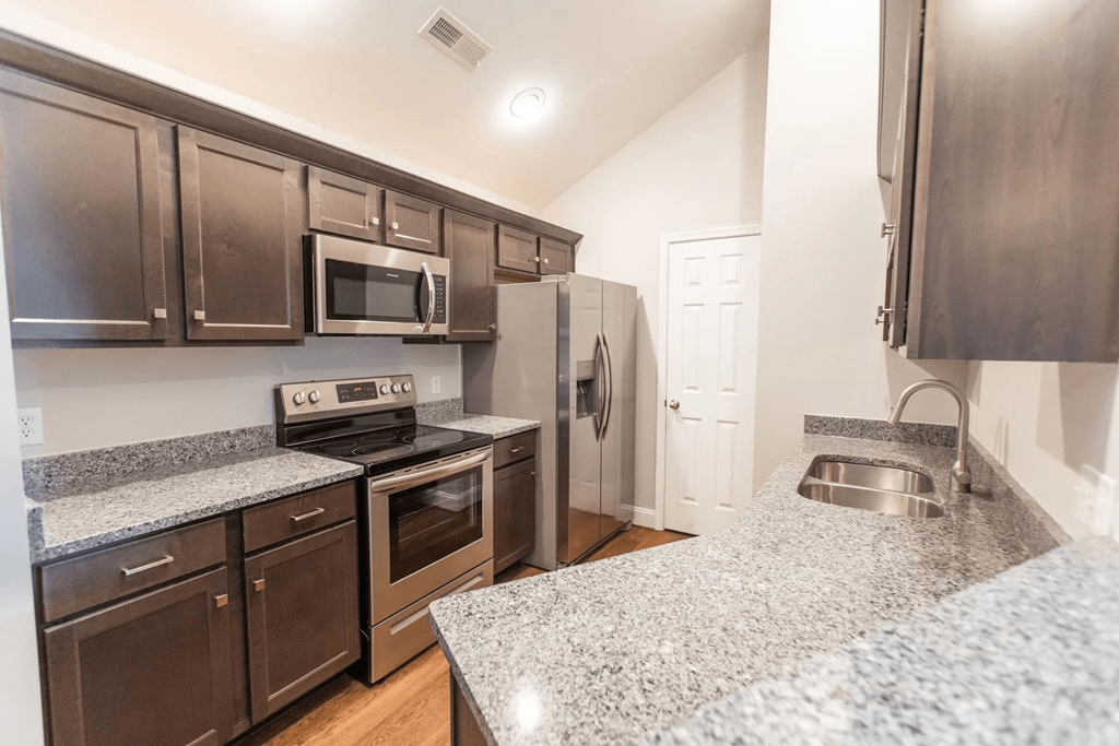 a kitchen with granite counter tops and stainless steel appliances