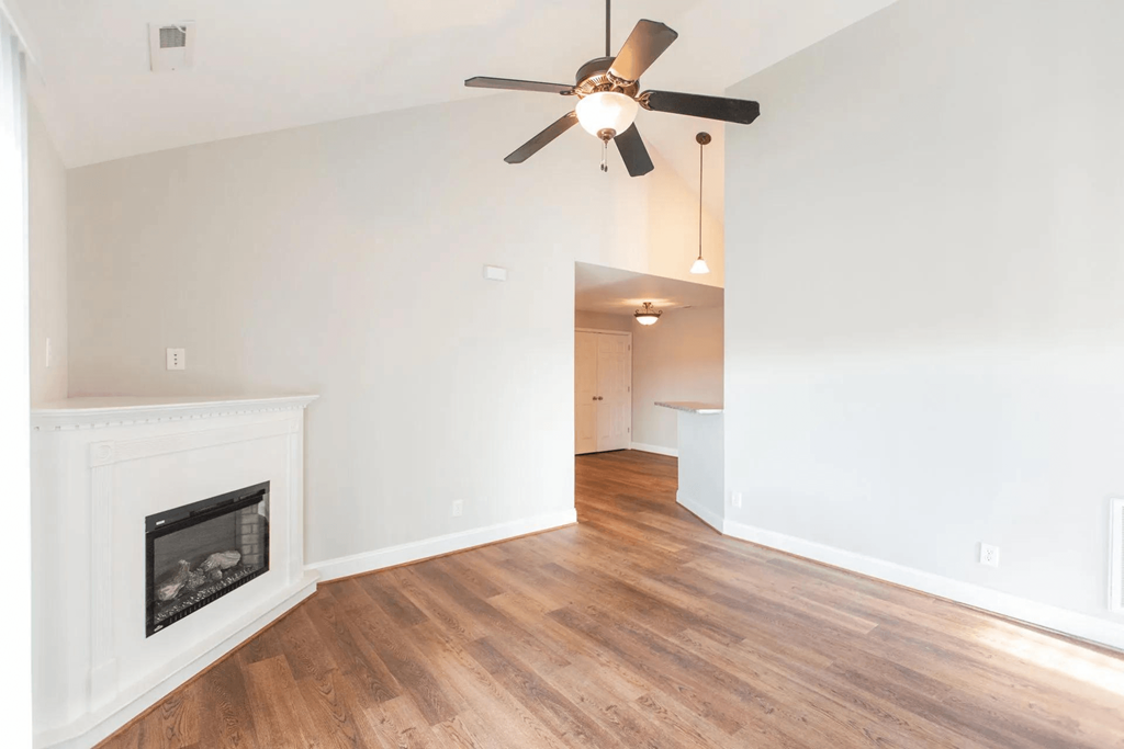 a living room with a fireplace and a ceiling fan