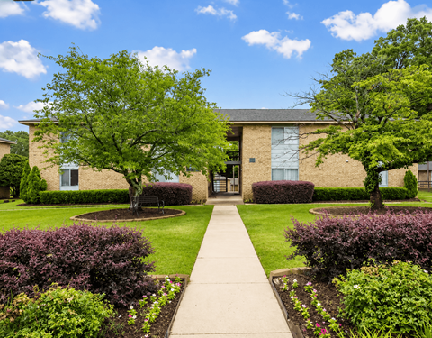 A building with a green lawn in front.