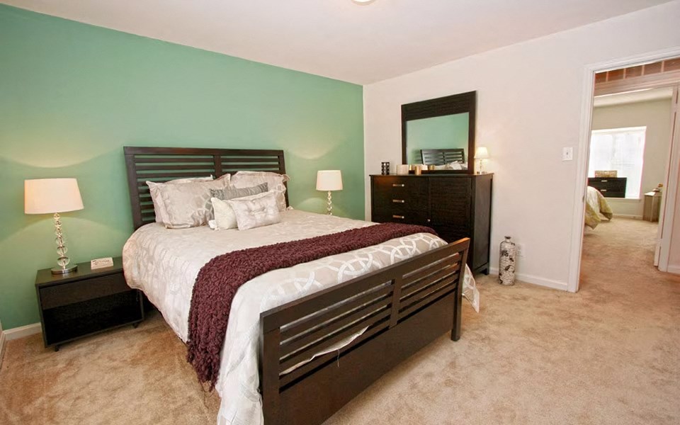 a bedroom with a bed and a dresser and a mirror