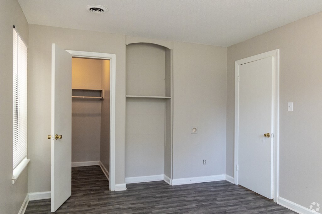 a living room with a closet and a door to a hallway