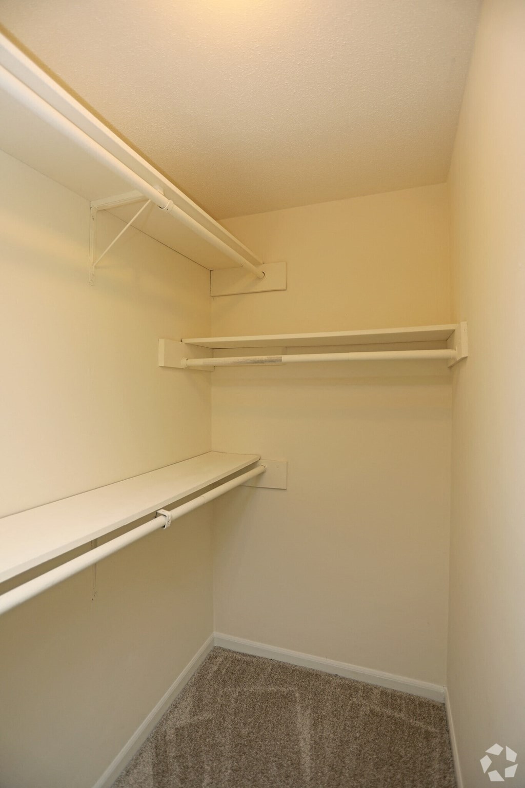 a walk in closet with shelves and a hanging shelf