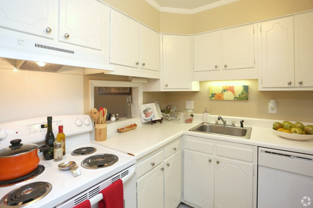 a kitchen with white cabinets and a stove and sink