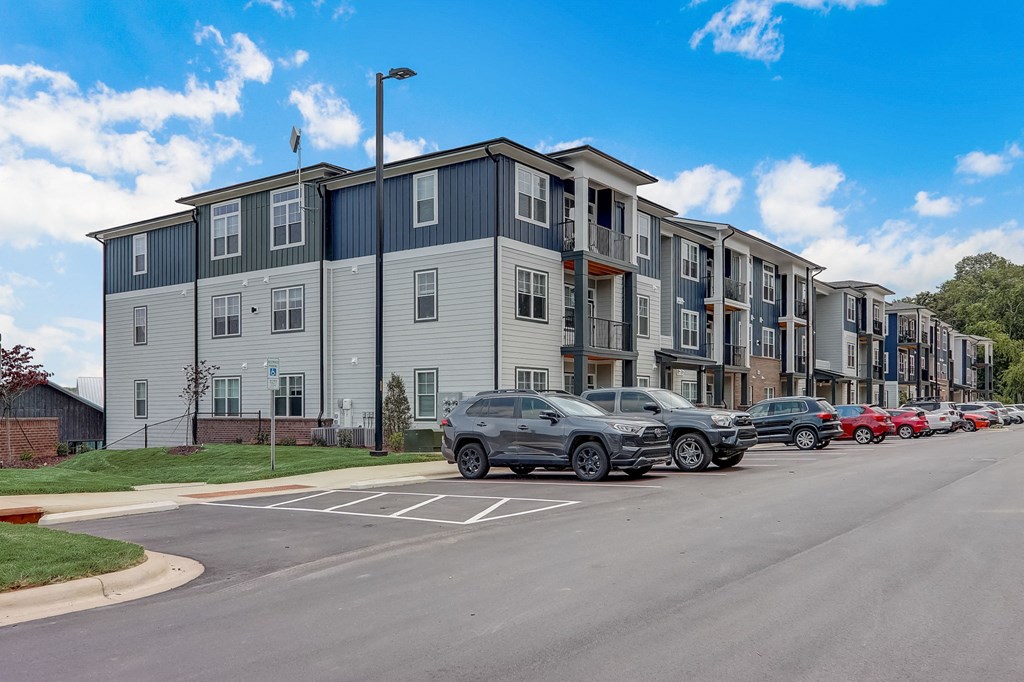 a row of apartment buildings with cars parked in front of them
