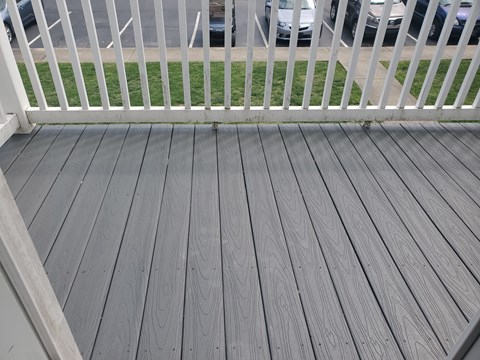 A wooden deck with a white railing.
