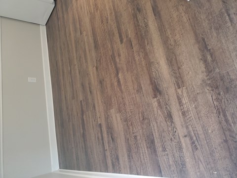 A room with a wooden wall and a white door.