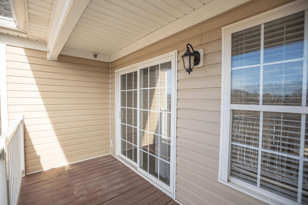 a porch of a home with large windows and a wooden deck