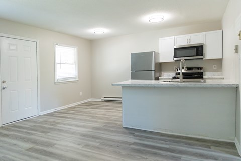 A kitchen with a white counter and a refrigerator.