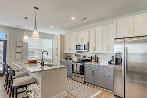 a large kitchen with stainless steel appliances and white cabinets