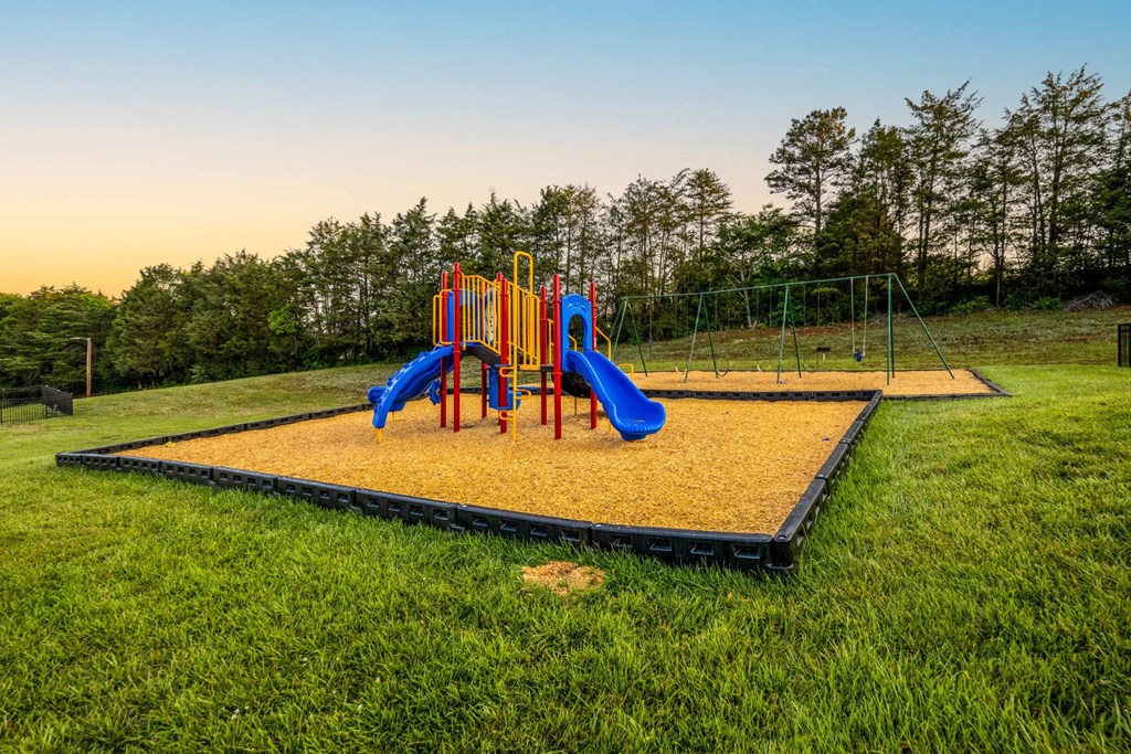 A playground with a yellow sandbox and a blue slide.