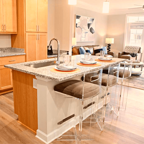 A kitchen with a granite countertop and a dining table set for four.
