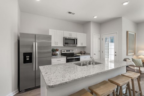 A modern kitchen with granite countertops and stainless steel appliances.