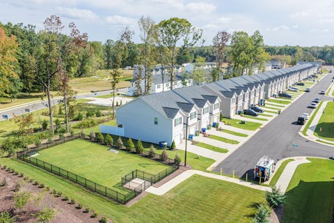 A row of houses with a green lawn in front.