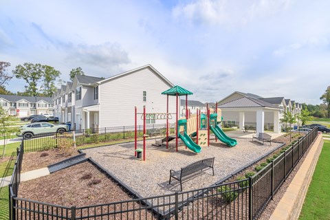 A playground with a green slide and red pole.