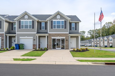 A grey house with a flag on top of it.
