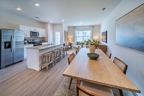 A modern kitchen with a wooden dining table and chairs.