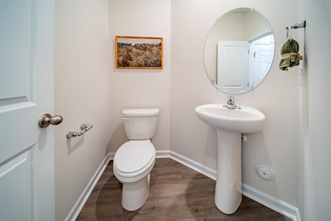 A white toilet and sink in a small bathroom.