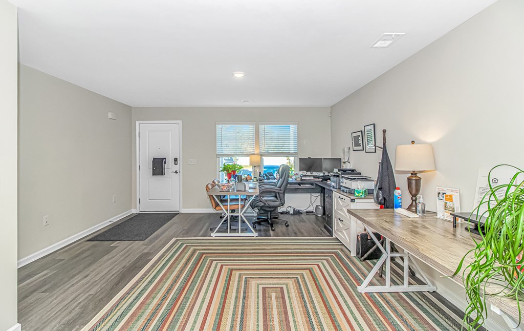A room with a striped rug and a desk with a computer.