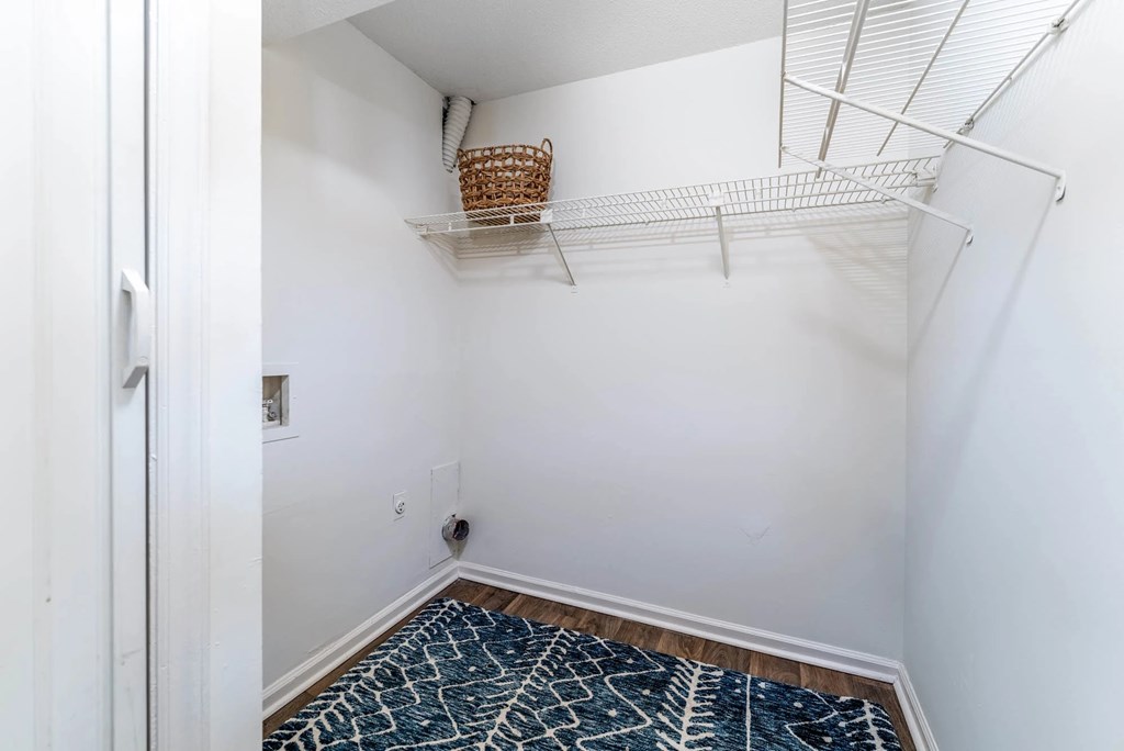A room with a basket on a shelf and a patterned carpet.