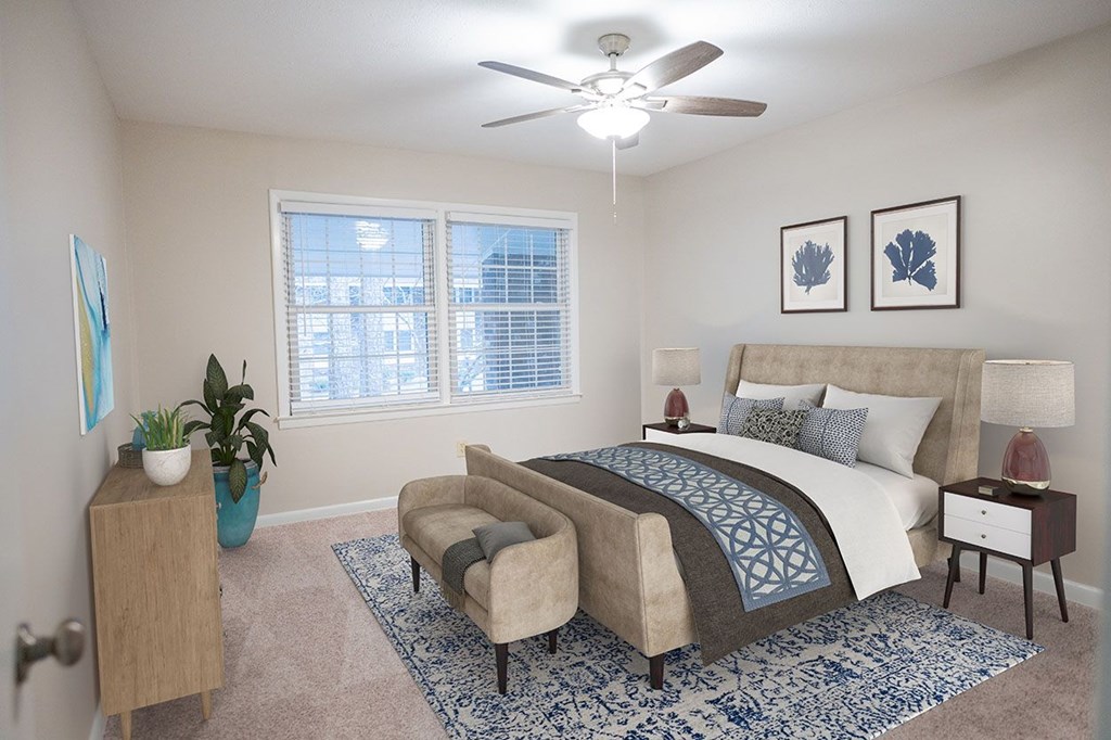 A bedroom with a large bed, a chair, and a ceiling fan.