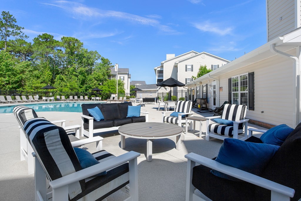 A patio with black and white striped chairs and a round table.