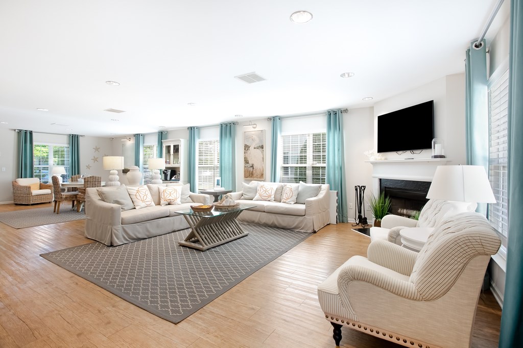 A living room with a grey rug and a white sofa.