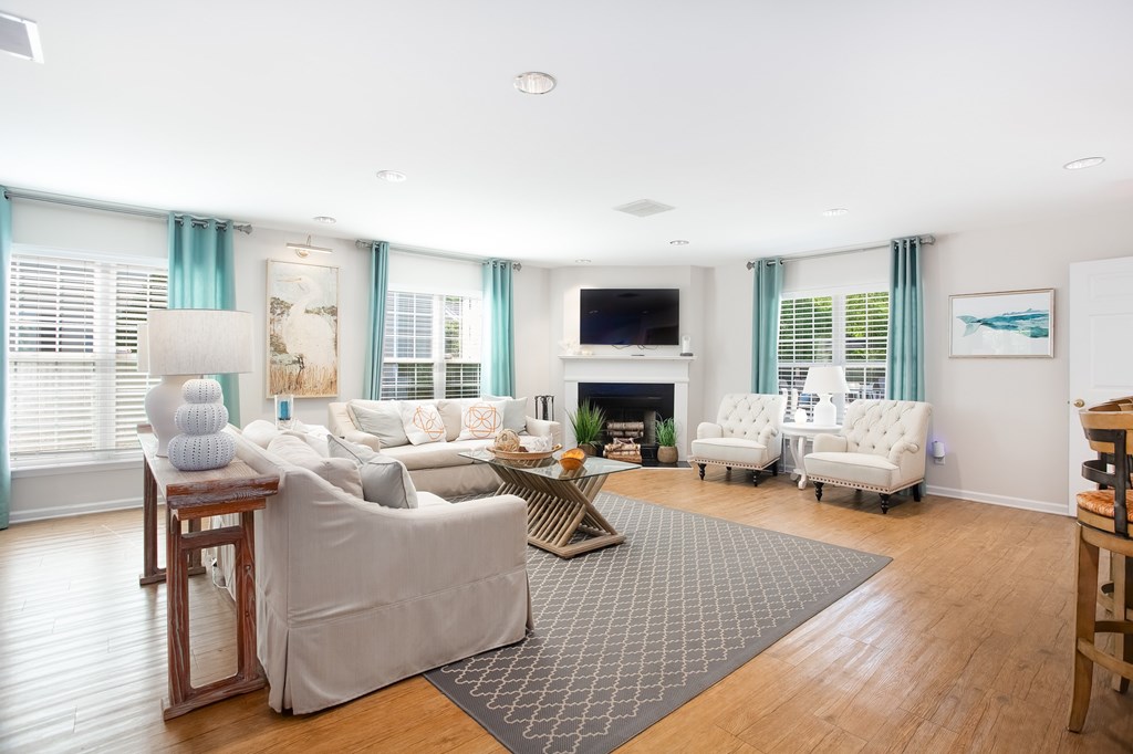 A living room with a grey couch and a fireplace.