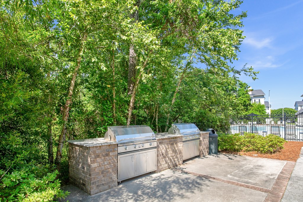 A tree-lined driveway leads to a house with a garage.