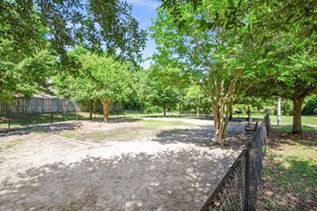 A park with a dirt area and trees.