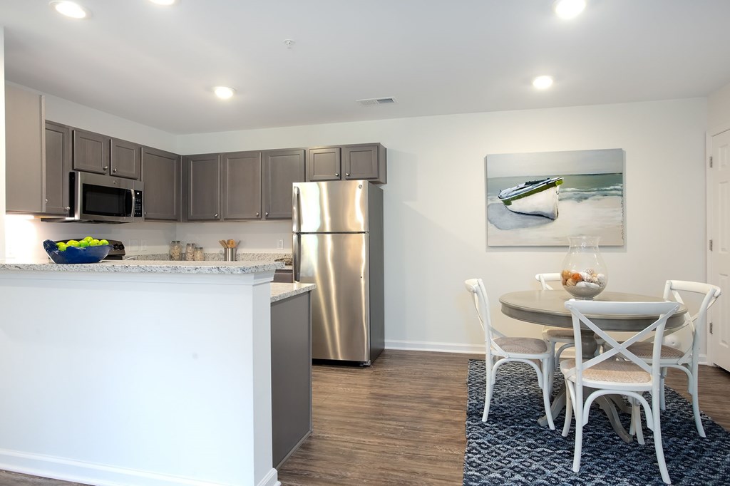 A kitchen with a white counter and a fridge.