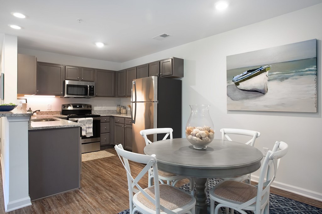 A modern kitchen with a dining table set for four.