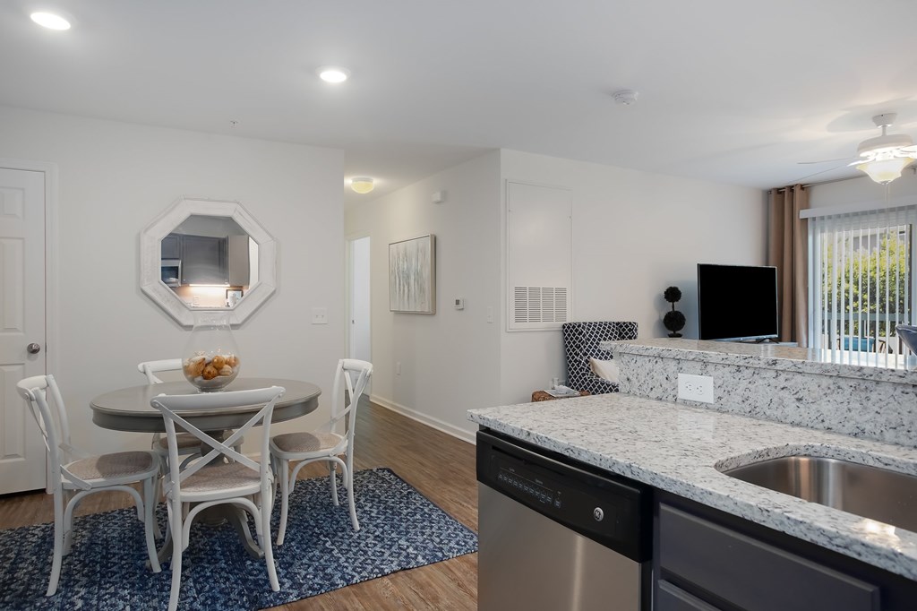 A kitchen with a table and chairs and a mirror on the wall.
