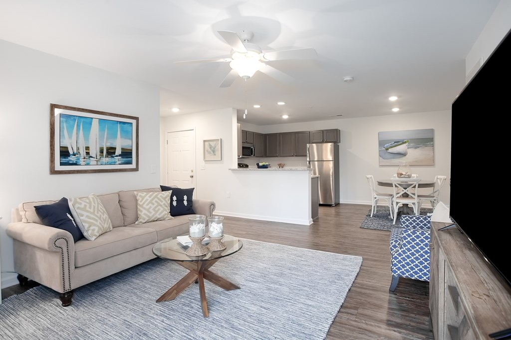 A living room with a beige couch, a coffee table, and a painting on the wall.