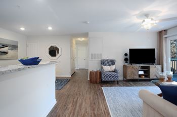 A living room with a white fireplace, a blue chair, and a television.