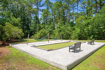 A backyard with a swing set and a sandbox.