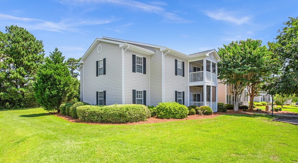 A house with a grey exterior and a red brick walkway in front.