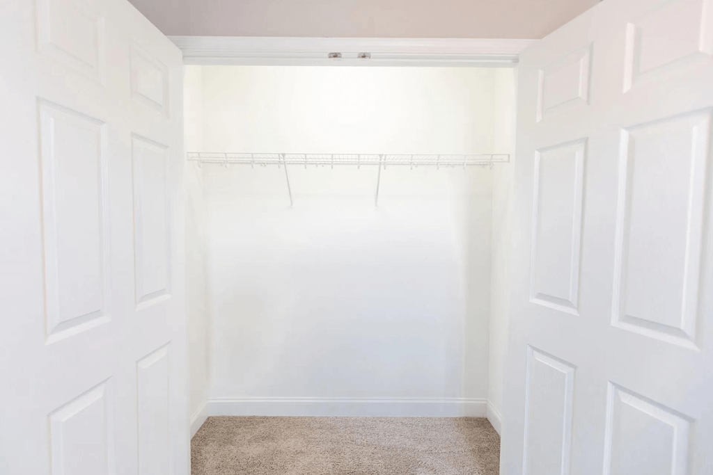 an empty closet with white walls and a white shower curtain