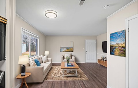 A living room with a couch, a coffee table, and a painting on the wall.
