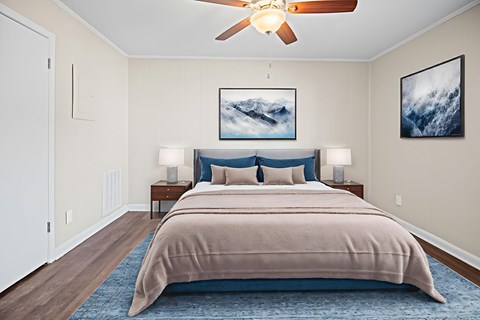 A bedroom with a large bed and a ceiling fan.